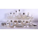 A COLLECTION OF MAINLY ANTIQUE SILVER MOUNTED SCENT BOTTLES in various forms and sizes. Birmingham 1
