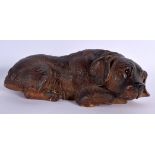 A 19TH CENTURY BAVARIAN BLACK FOREST FIGURE OF A DOG modelled sleeping. 22 cm x 11 cm.