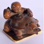 A 19TH CENTURY JAPANESE MEIJI PERIOD CARVED NUT OKIMONO modelled as a male upon a bear, supported up