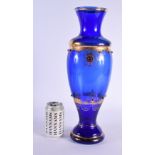 A LARGE EARLY 20TH CENTURY CONTINENTAL JEWELLED BLUE GLASS VASE decorated all over with gilt foliage