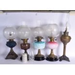 A GROUP OF FIVE ANTIQUE OIL LAMPS in various forms and sizes. Largest 65 cm long. (5)