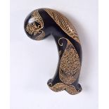 An Islamic hard stone dagger handle decorated with gilt flowers, 15 cm