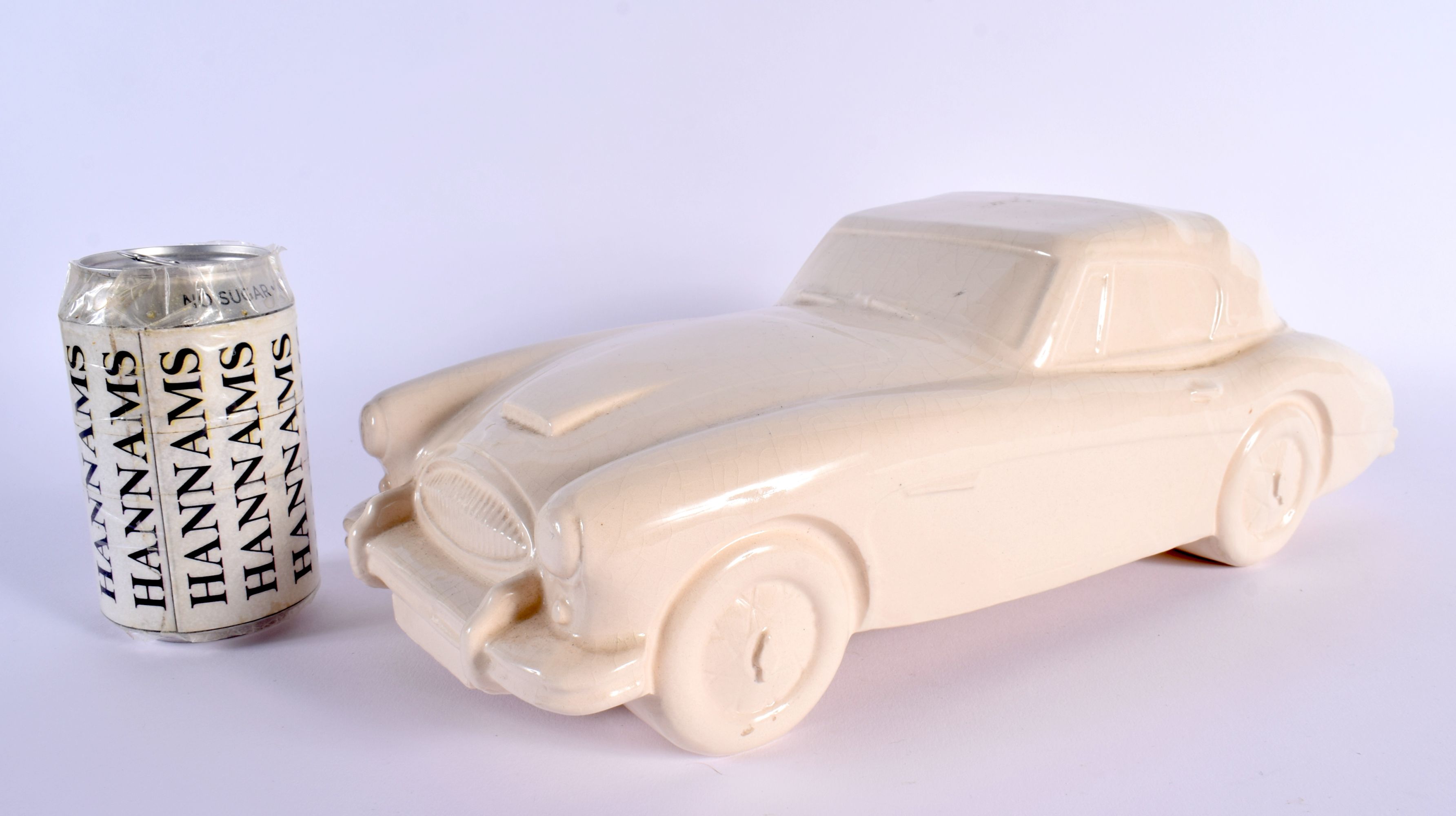 A CHARMING BRISTOL POTTERY MODEL OF A VINTAGE CAR by Ted Eric Wayman. 37 cm wide.