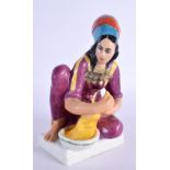 A RARE RUSSIAN PORCELAIN FIGURE OF A SEATED FEMALE modelled washing clothes. 15 cm x 8 cm.