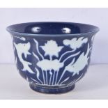 A Chinese porcelain sacrificial blue bowl decorated in relief with fish 11 x 16 cm.