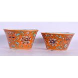 A RARE NEAR PAIR OF 19TH CENTURY CHINESE CORAL GROUND BOWLS Late Qing. Largest 9.5 cm diameter. (2)