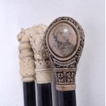 A collection of three ebonised wooden walking canes, one with a Horatio Nelson handle. Longest 99cm