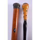 AN ANTIQUE AMBER HANDLED PARASOL and a silver mounted cane. Largest 88 cm long. (2)