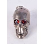 A WHITE METAL SKULL PENDANT WITH GEM SET EYES AND AN ARTICULATED JAW. 3cm x 2.8cm x 2cm
