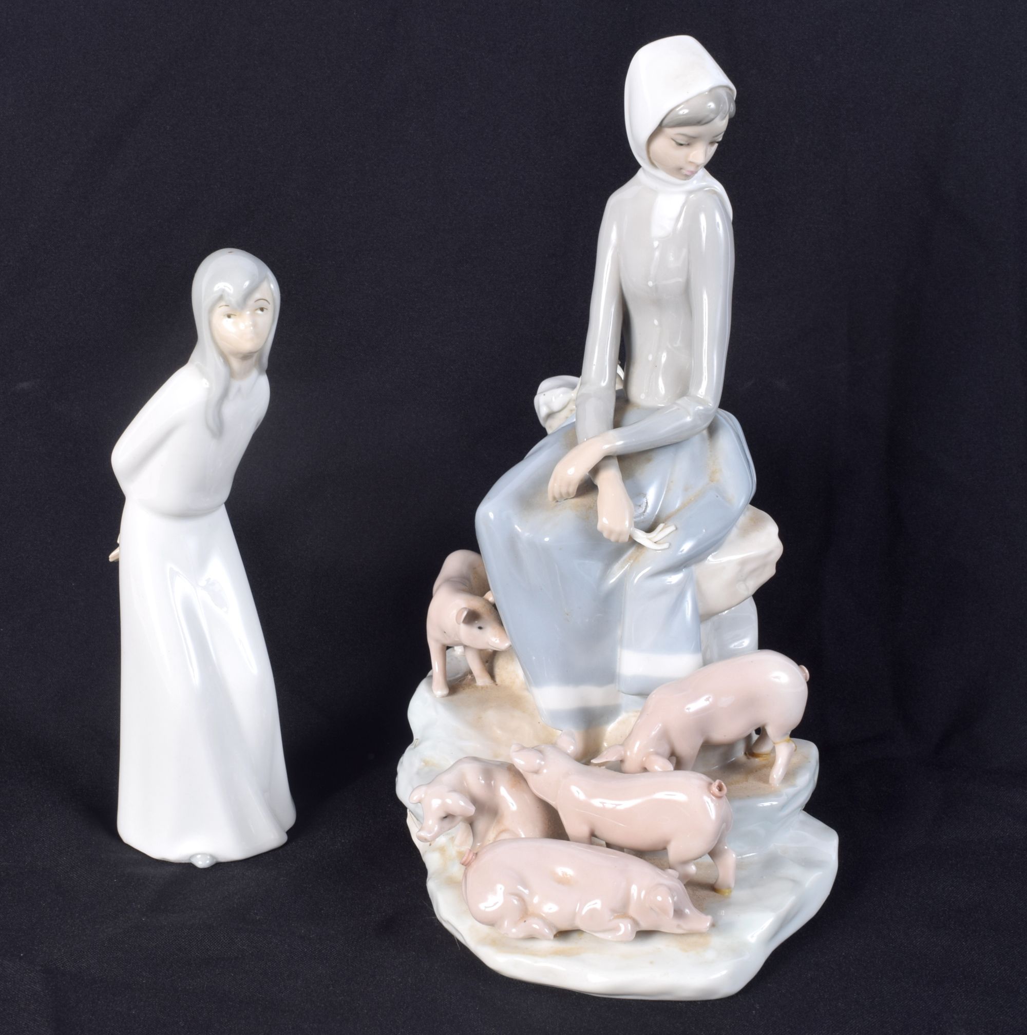 A large Lladro figure of a female with her pigs together with another figurine 28 cm (2).