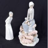 A large Lladro figure of a female with her pigs together with another figurine 28 cm (2).