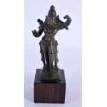 A 19TH CENTURY MIDDLE EASTERN INDIAN BRONZE DEITY upon a wooden plinth. 14 cm high.