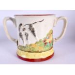 A 19TH CENTURY ENGLISH TWIN HANDLED FROG MUG decorated with dogs and game. 21 cm wide.