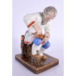 A RUSSIAN PORCELAIN FIGURE OF A SEATED MALE modelled repairing shoes. 15 cm x 8 cm.
