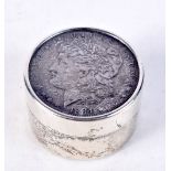 A STERLING SILVER COIN BOX WITH A US DOLLAR IN THE COVER. Stamped Sterling, 4cm x 2.5cm, weight 71g