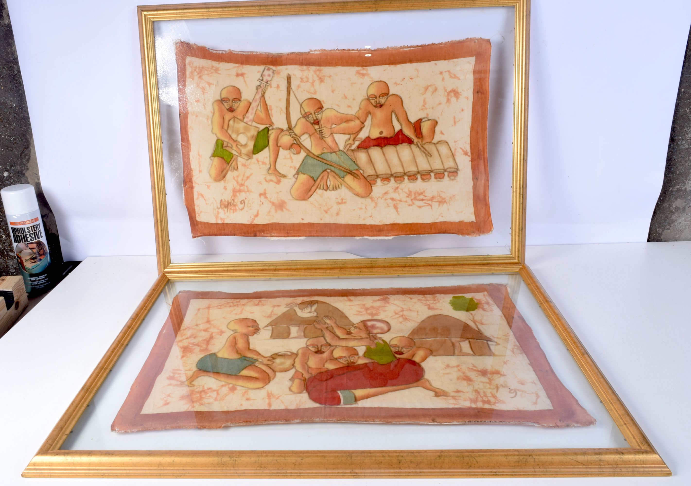 A pair of framed painted fabrics depicting tribal subjects 37 x 52 cm (2).