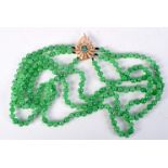 A THREE STRAND GREEN JADE NECKLACE WITH A GOLD CLASP SET WITH DIAMONDS. Marked MGM, length 55cm, Be