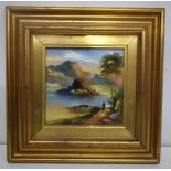 A framed porcelain plaque of a lakeside castle 14 x 14 cm.