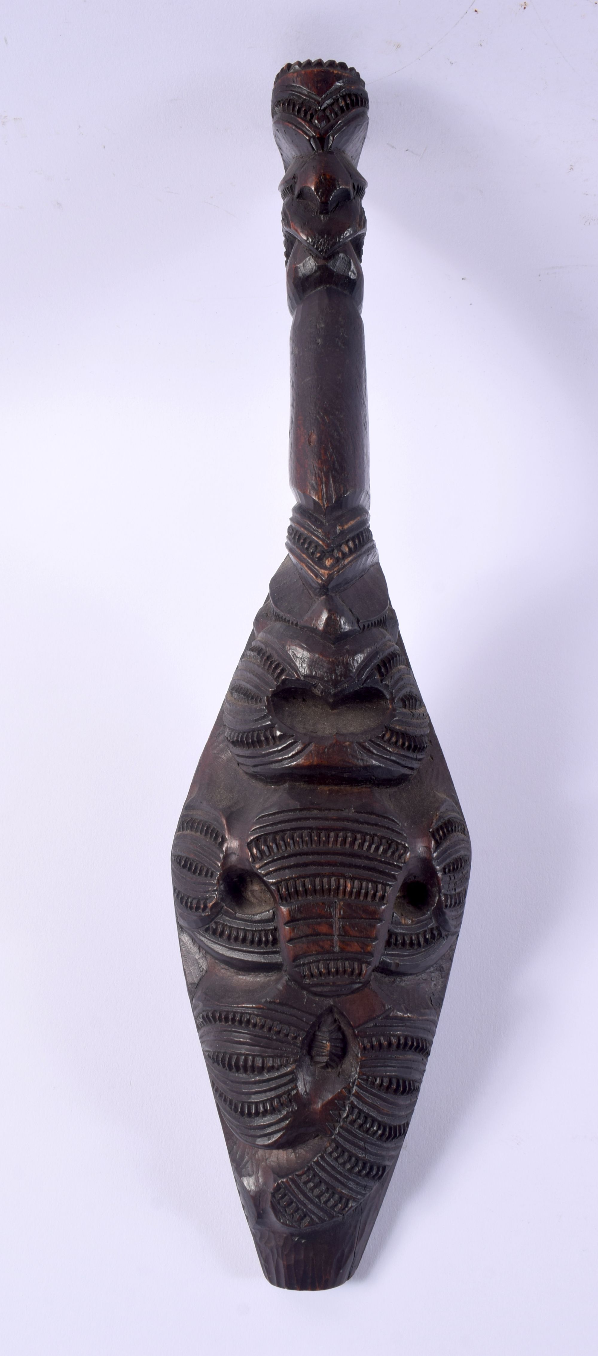 AN UNUSUAL EARLY 20TH CENTURY MAORI TRIBAL NEW ZEALAND CARVED WOOD CLUB possibly a Wahaiki, with fla