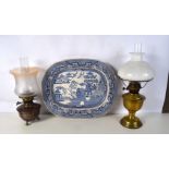 A collection of Oil lamps together with a ceramic platter.51 x 41 cm. (3).