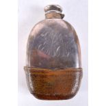 AN ANTIQUE WHITE METAL AND LEATHER HIP FLASK. 290 grams. 8.5 cm x 14.5 cm.