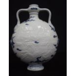 A Chinese porcelain blue and white Moon flask decorated in relief with dragon 28 cm.
