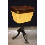 A Victorian wooden inlaid sewing box with a material body and ebonised legs on castors 77 x 46 x 37