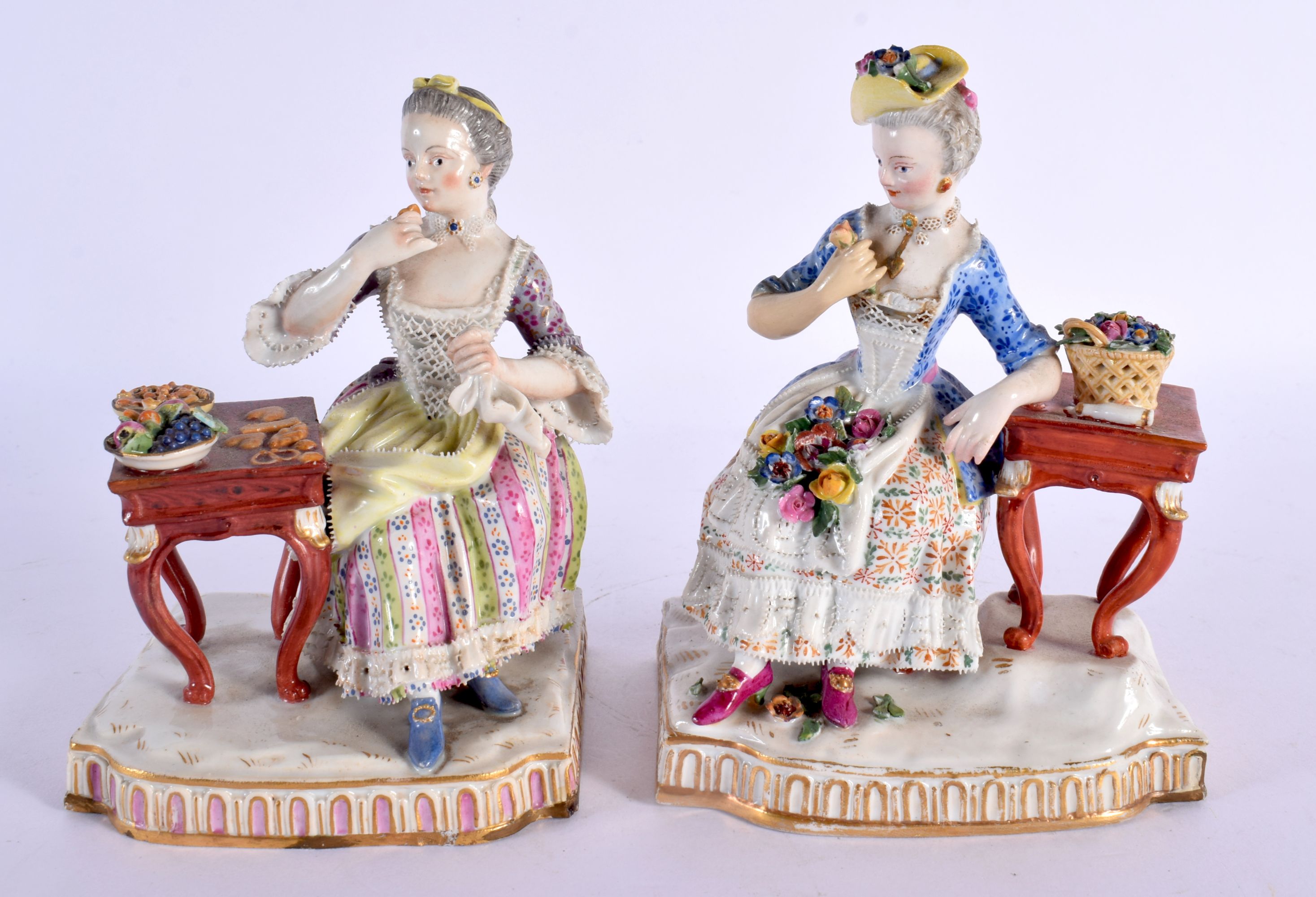 A PAIR OF 19TH CENTURY GERMAN MEISSEN PORCELAIN FIGURAL GROUPS modelled beside a table. 14 cm x 11 c