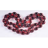 A CHERRY AMBER COLOURED BEAD NECKLACE. 88cm long