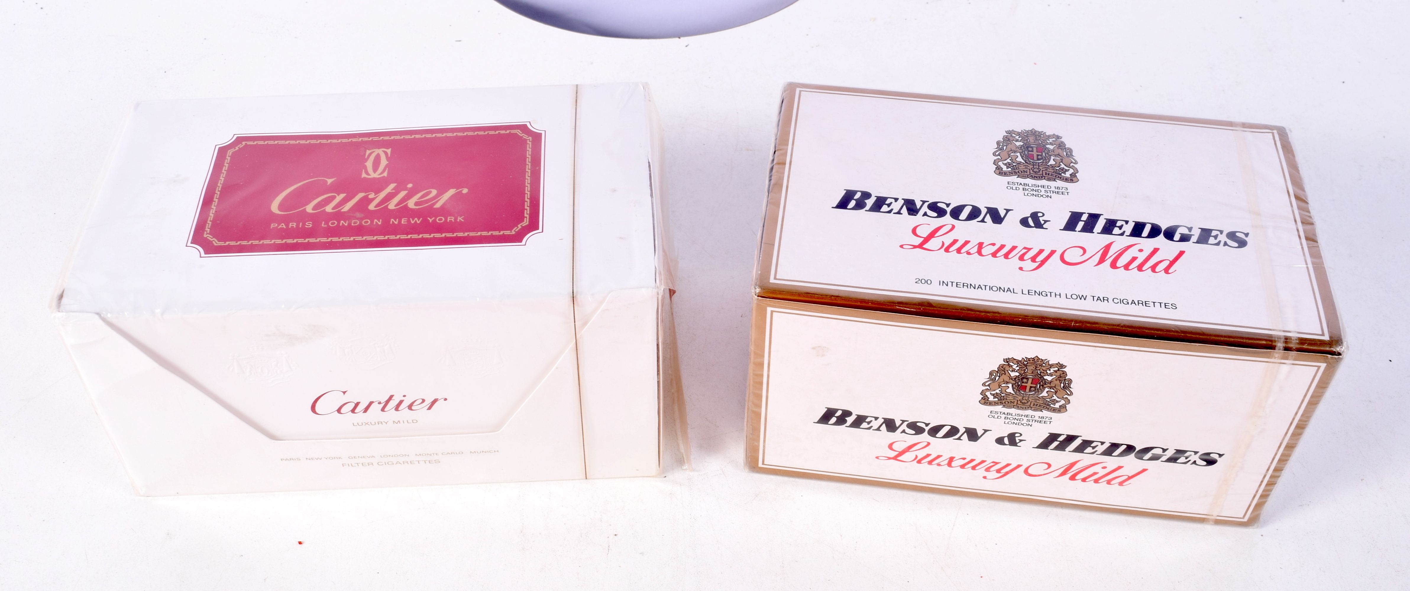 A pack of unopened Cartier cigarettes together with a pack of Benson and Hedges (2).