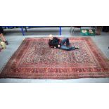 A VERY LARGE PERSIAN RED AND BLUE GROUND COUNTRY HOUSE CARPET decorated all over with foliage and vi