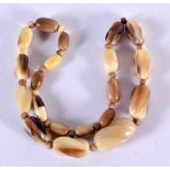 A CARVED HORN BEAD NECKLACE. Length 46cm, largest bead 13.8mm