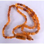 AN AMBER NECKLACE. 95 grams. 104 cm long, largest bead 5 cm x 2.75 cm.