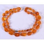 AN AMBER TYPE BEAD NECKLACE. 75cm long, largest bead 13.6mm, weight 33g