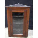An antique mahogany glass fronted wall hung corner unit 98 x 64 x 32 cm.