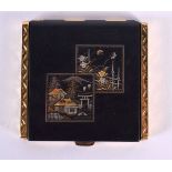 A JAPANESE TAISHO PERIOD MIXED METAL COMPACT decorated with landscapes. 7.5 cm square.