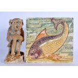 AN UNUSUAL GROTESQUE STUDIO POTTERY FIGURE OF AN IMP together with an Arts and Crafts type tile. Lar