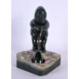 A LOVELY NORTH AMERICAN INUIT CARVED JADE FIGURE OF A SEAL HUNTER modelled upon a naturalistic base.