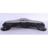 A LARGE ANTIQUE SRI LANKAN CARVED WOOD FLORAL WRAPPED STAND inset with a central elephant. 34 cm x 3