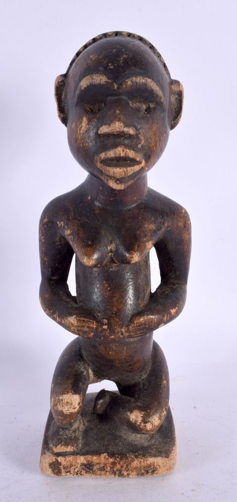 AN AFRICAN TRIBAL CARVED WOOD FIGURE. 21 cm high.