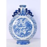 A Chinese porcelain blue and white moon vase, twin handled and decorated with a dragon and phoenix.