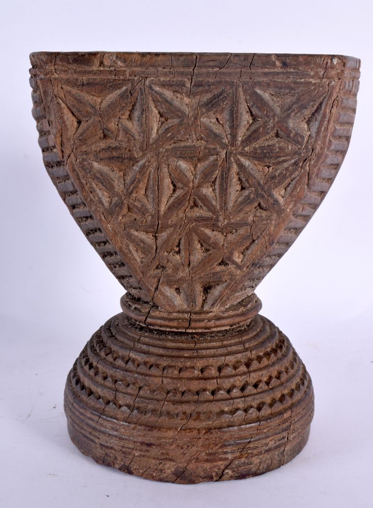 AN UNUSUAL TRIBAL INDIAN CARVED WOOD STAND decorated with star crossed motifs. 16 cm x 14 cm.