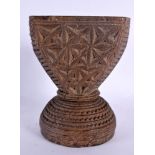 AN UNUSUAL TRIBAL INDIAN CARVED WOOD STAND decorated with star crossed motifs. 16 cm x 14 cm.