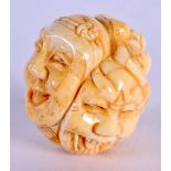 A JAPANESE CARVED BONE MASK BALL. 3.5 cm wide.