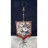 A Victorian embossed brass embroidered fire screen converted to a lamp. 141 x 47 cm