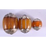 THREE EARLY 20TH CENTURY MIDDLE EASTERN SILVER AND AMBER TOGGLES. Largest 4 cm x 3 cm. (3)