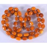 AN AMBER TYPE BEAD NECKLACE 120cm long, largest bead 14.4mm
