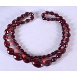 A CHERRY AMBER TYPE NECKLACE. Necklace 77cm long, largest bead 19.5mm, weight 49g
