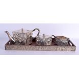 AN EARLY 20TH CENTURY JAPANESE MEIJI PERIOD SILVER AND HARDWOOD TEASET decorated with foliage. 890 g