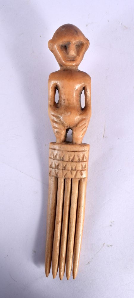 A RARE 19TH CENTURY AFRICAN CARVED BONE TRIBAL COMB formed with a standing figure.18 cm long.